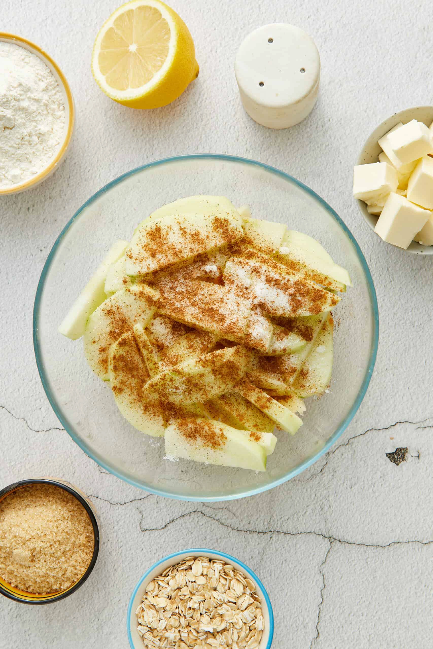 Photo of second step in recipe-- sliced apples covered in sugar, and cinnamon.